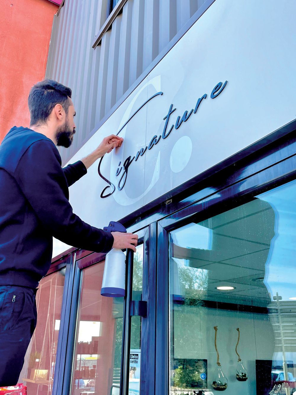Pose d'un adhésif sur une vitrine - enseigne boutique